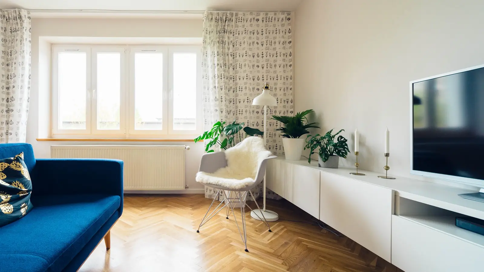 A finished apartment room with parquet flooring and fitted storage